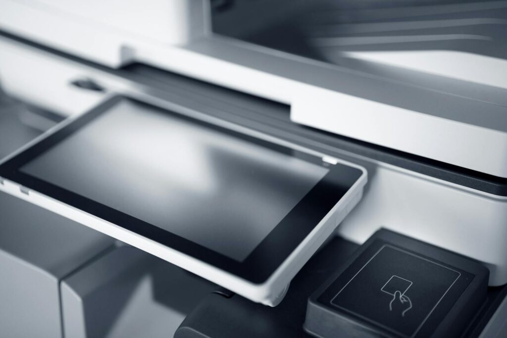 Close-up of a modern printer with a touchscreen interface in a professional office setting.
