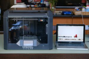 silver macbook pro on white table