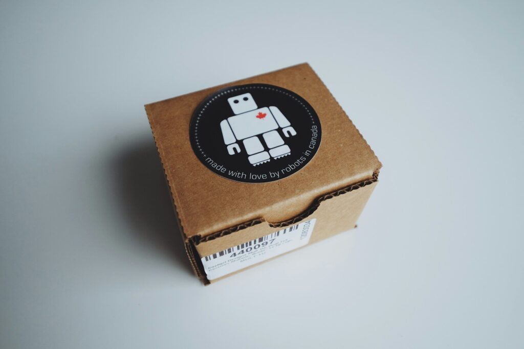 Kako odabrati nalepnice za staklo, plastiku, karton i metalnu ambalažu 4 Small cardboard box with a robot sticker on top