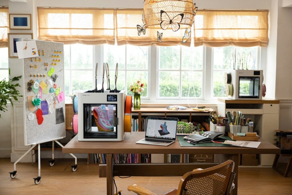 3D printers and crafting supplies on a desk.